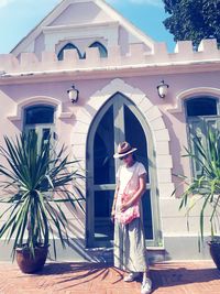 Rear view of woman standing by building