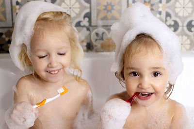 Cute girls brushing teeth in bathtub