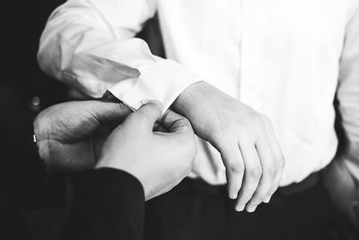 Close-up of male hands adjusting cufflinks of groom