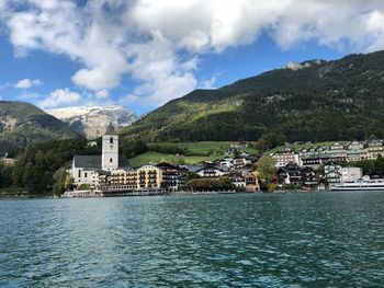 Scenic view of sea and buildings in town against sky