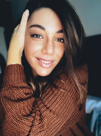 Portrait of smiling young woman sitting at home