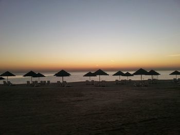 Scenic view of beach against clear sky during sunset