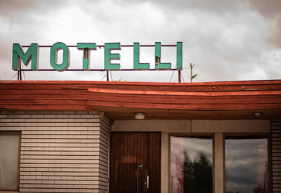 Low angle view of text on building against sky