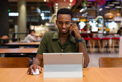 Businesswoman using laptop while sitting at cafe