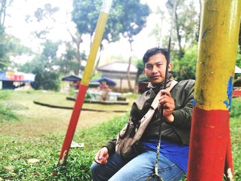 Portrait of young man sitting on land