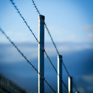 Close-up of barbed wire against sky