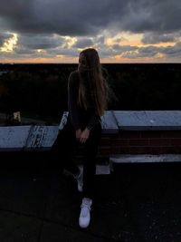 Full length of woman standing against sky during sunset