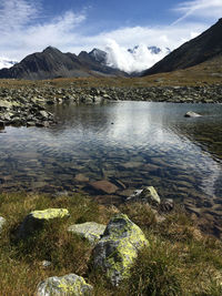 Scenic view of lake by mountains against sky