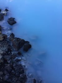 Rock formation in sea against blue sky