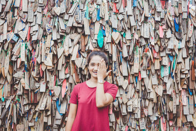 Portrait of woman standing against various wooden prayer blocks