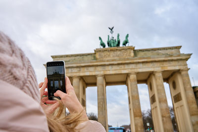 Woman taking picture of brandenburg gate in berlin, germany