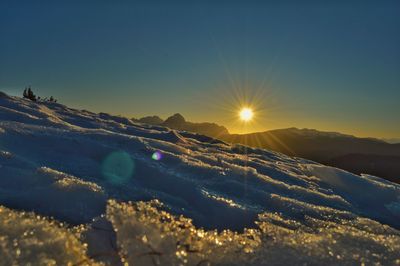 Scenic view of snowcapped mountains against sky during sunset