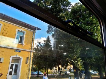 Low angle view of building seen through glass window