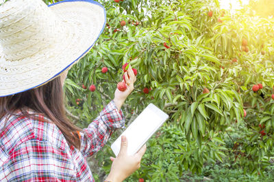 Portrait of a girl holding hat on plant