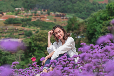 Portrait of beautiful woman amidst flowering plants