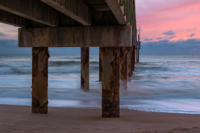 Wooden pier on sea against sky during sunset