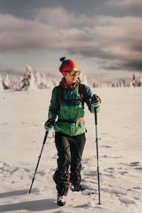 Low angle view of man standing on snow covered field