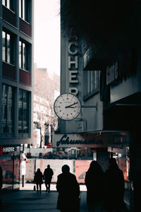 Rear view of people on street amidst buildings in city