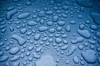 Full frame shot of raindrops on blue water