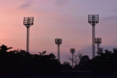 Low angle view of street lights against sky at sunset