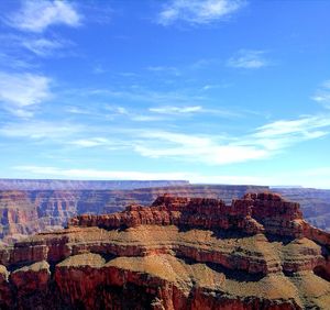 Rock formations on landscape against cloudy sky