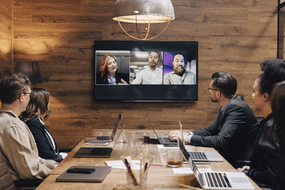Multiracial colleagues planning strategy through video conference in board room