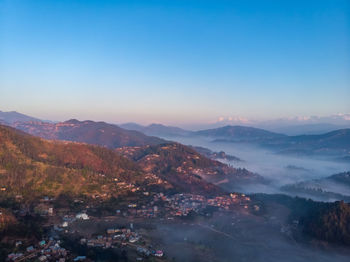 Scenic view of mountains against clear sky during sunrise