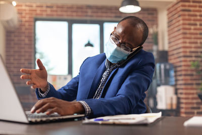 Man using phone while sitting on table