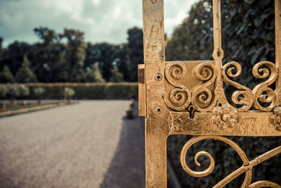 Close-up of metal gate against sky