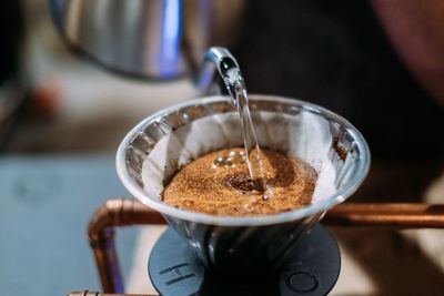 Close-up of hand pouring coffee in cup