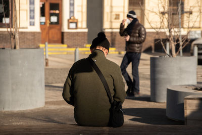 Rear view of people on street in city during winter