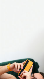 Low section of woman using mobile phone against white background