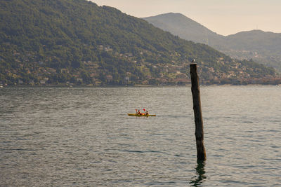 Tourists kayaking on the maggiore lake, baveno, piedmont, italy