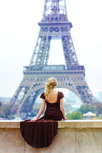 Rear view of woman against tower