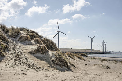 Wind turbines on land against sky