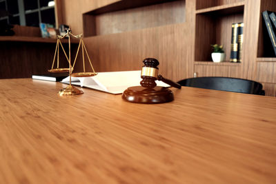Close-up of gavel and weight scale on table
