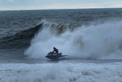 Scenic view of waves in sea against sky