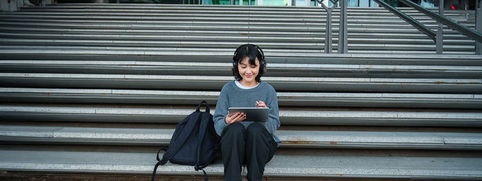 Portrait of young woman standing on steps