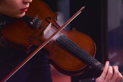 Midsection of woman playing violin