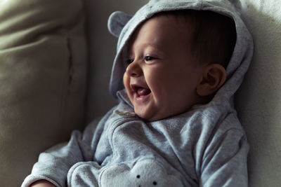 Cute smiling baby lying down on sofa