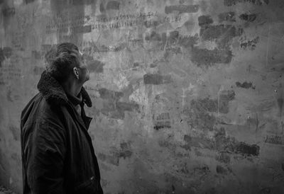 Man looking at damaged wall