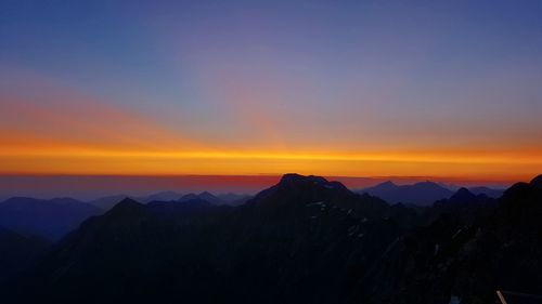 Scenic view of silhouette mountains against romantic sky at sunset