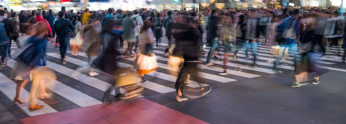 Crowd walking on street in city