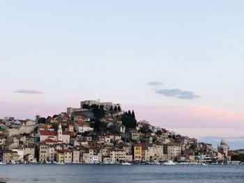 Townscape by sea against sky in city