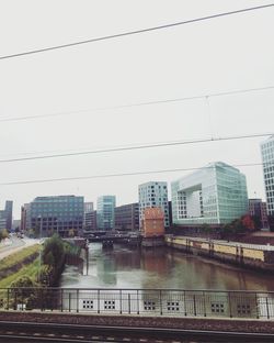 Bridge over canal in city against sky