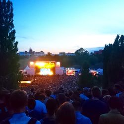 Crowd at music concert against sky at night