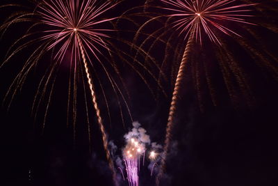 Low angle view of firework display at night