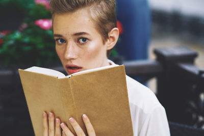 Portrait of young woman reading book