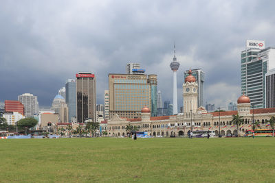 Buildings in city against cloudy sky