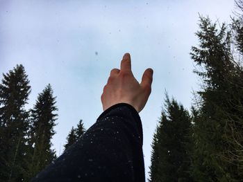 Cropped hand of man against sky